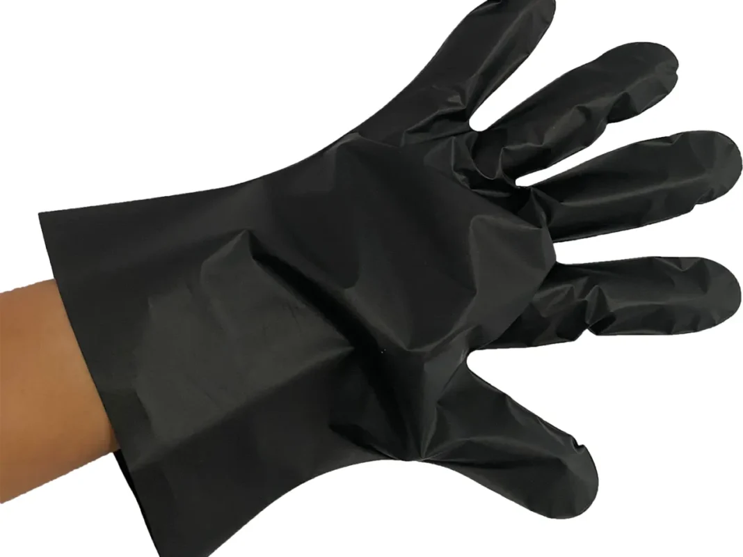 Black plastic glove on human hand, white background